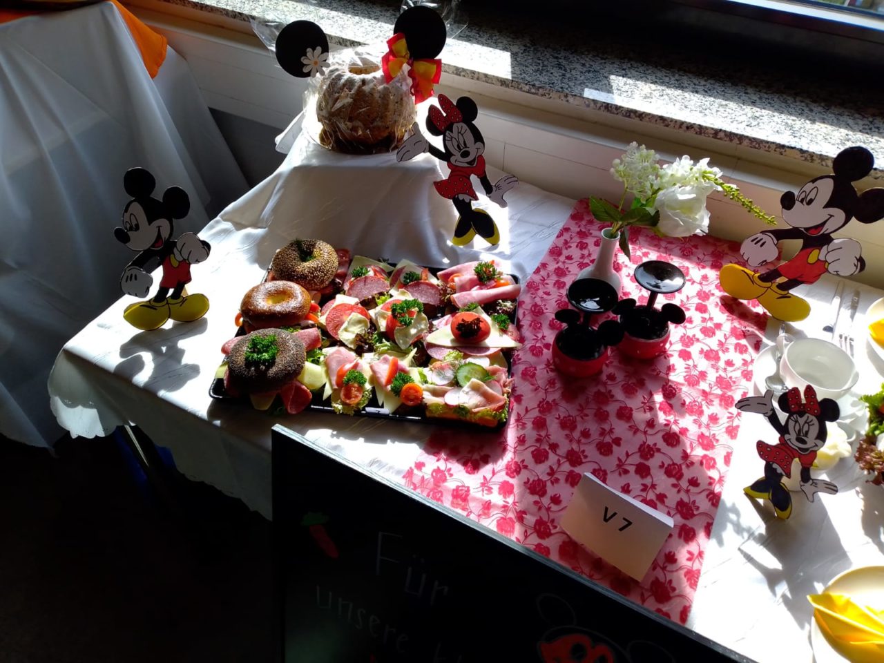 Buffettisch mit Mickey-Mouse-Dekoration und belegten Brötchen