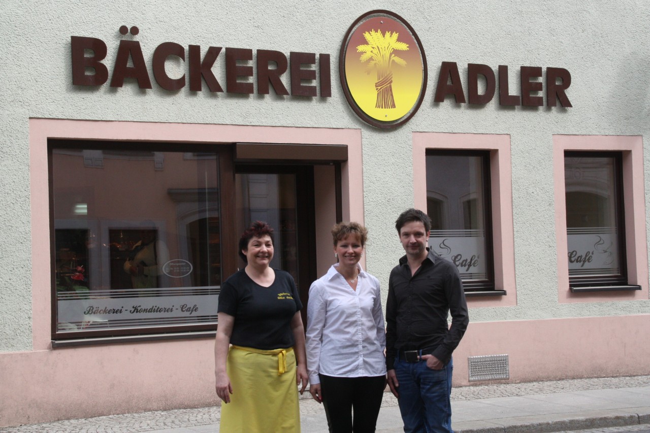 Angestellte stehen vor dem Stammhaus Bäckerei Adler